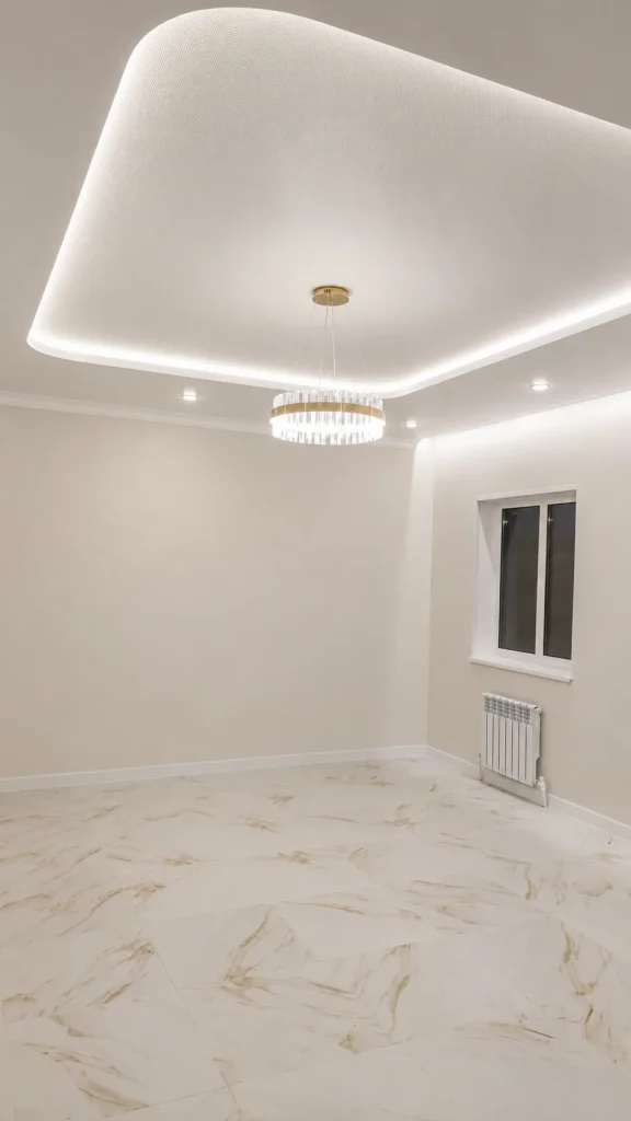 Multi-level stretch ceiling with rounded LED lighting and chandelier in a London interior