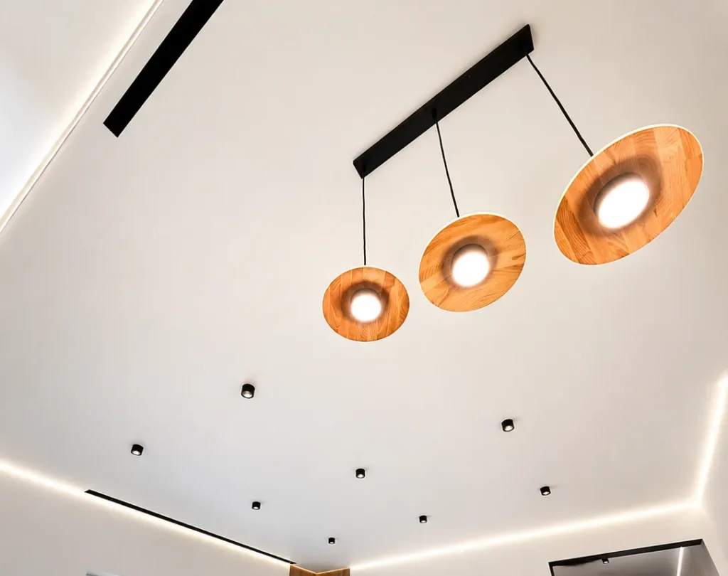 Shadow stretch ceiling with pendant lights and perimeter LED lighting in a modern living room