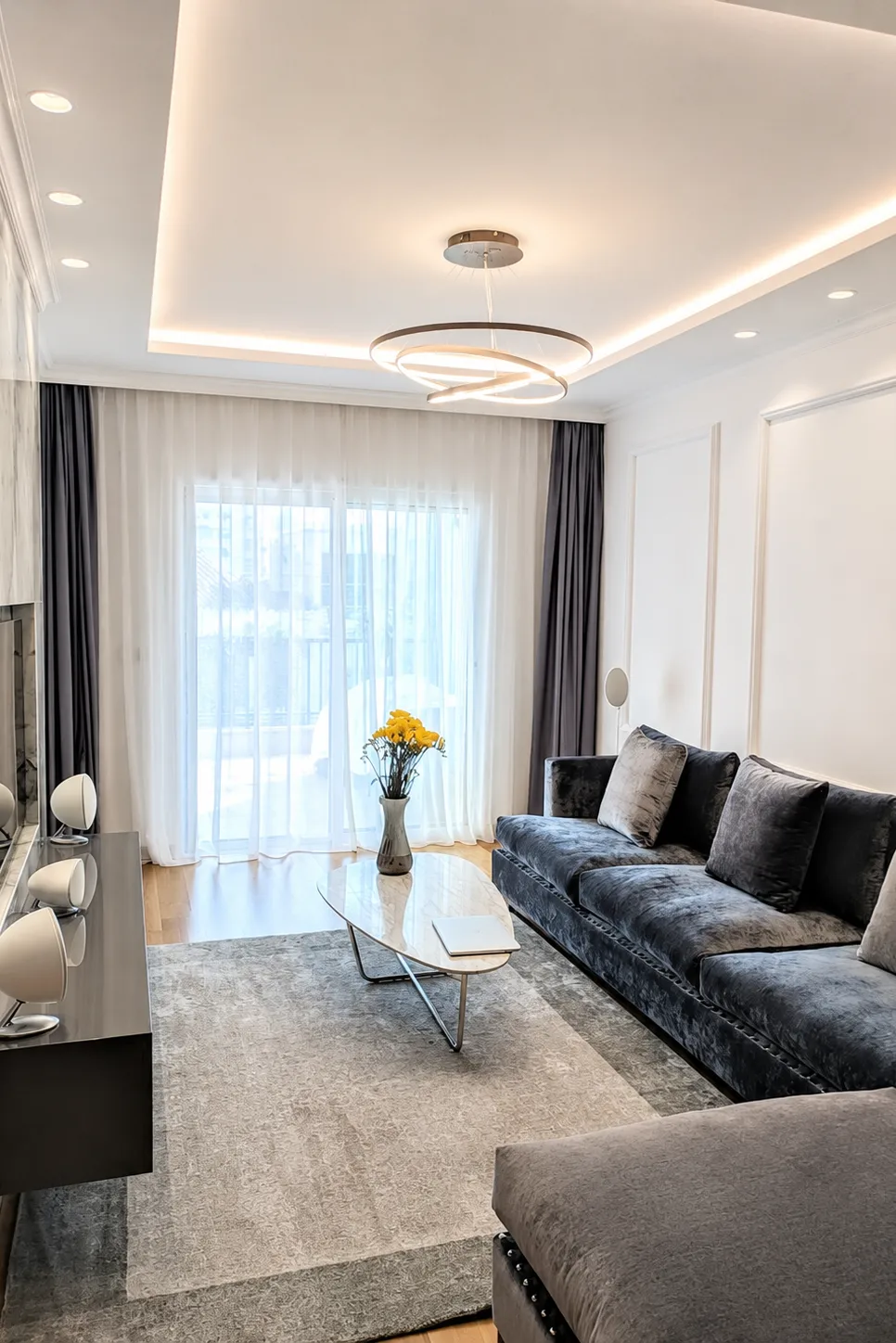 Kent Satin stretch ceiling with chandelier and warm LED lighting in a modern living room